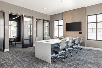 A conference room with a white desk and chairs.